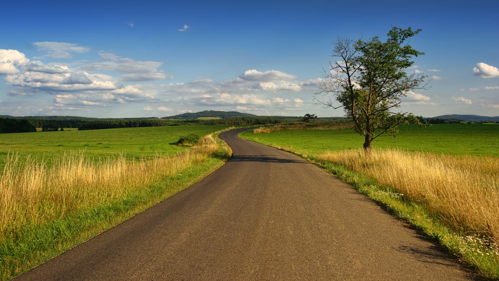 Photo of Road in the Middle of the Grass Field